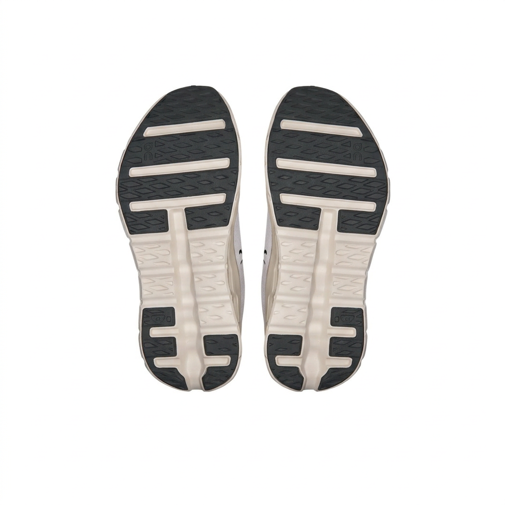 On Cloudtilt ivory and black outsoles, bottom view on a white background